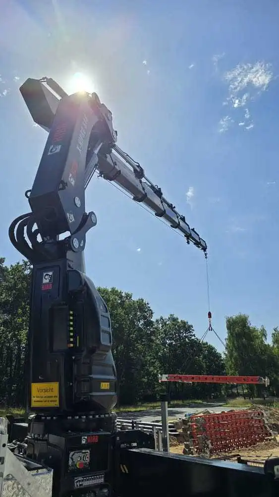 Kranarbeiten auf der Baustelle – präzises Versetzen von Bauelementen mit dem Ladekran.